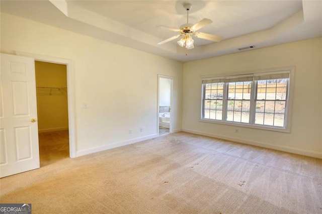 915 Cruce Lake Dr, Hoschton, GA 30548 - spare room with a ceiling fan, visible vents, baseboards, a tray ceiling, and light colored carpet
