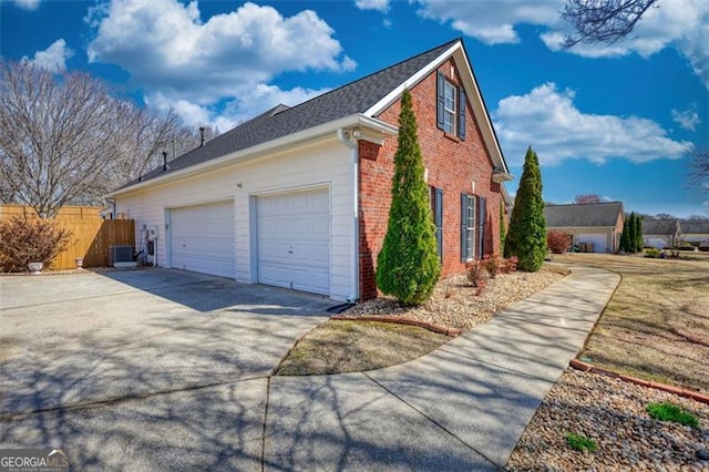 915 Cruce Lake Dr, Hoschton, GA 30548 - view of side of property featuring cooling unit, fence, an attached garage, concrete driveway, and brick siding