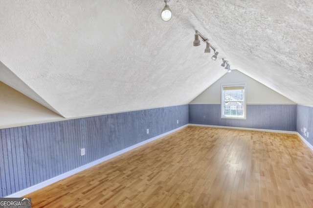 915 Cruce Lake Dr, Hoschton, GA 30548 - bonus room with baseboards, a textured ceiling, wood finished floors, and vaulted ceiling