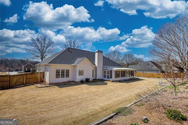 915 Cruce Lake Dr, Hoschton, GA 30548 - back of house with fence, a lawn, a chimney, and a sunroom