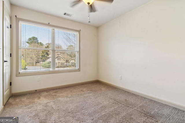 unfurnished room featuring baseboards, visible vents, a ceiling fan, and carpet