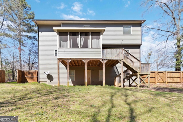 rear view of house featuring stairway, a gate, fence, a yard, and a sunroom