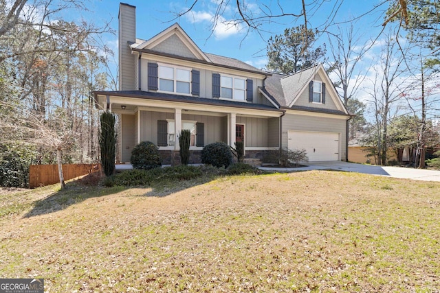 view of front of house with a front lawn, driveway, stone siding, fence, and covered porch