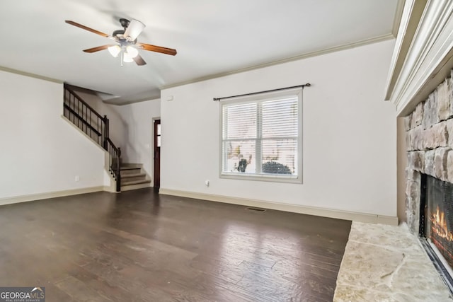 unfurnished living room with stairs, ornamental molding, wood finished floors, and ceiling fan