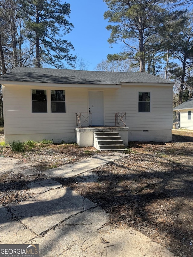 view of front of property with crawl space and a shingled roof