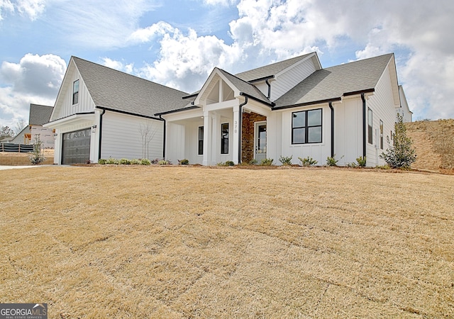 modern farmhouse style home featuring a front lawn, board and batten siding, a shingled roof, and an attached garage