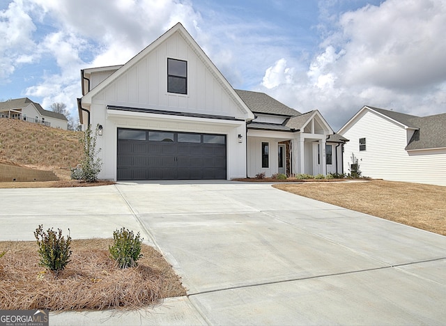 modern farmhouse featuring concrete driveway, board and batten siding, and roof with shingles