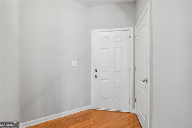 corridor with light wood-style flooring and baseboards