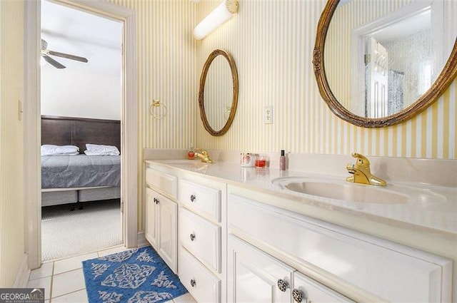 ensuite bathroom with tile patterned flooring, double vanity, wallpapered walls, and a sink