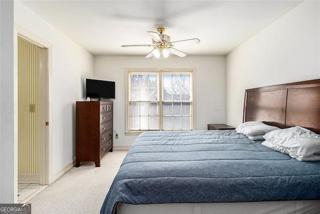 bedroom with light carpet, a ceiling fan, and baseboards