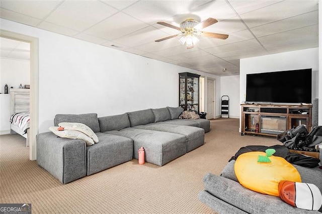 carpeted living room with a drop ceiling and a ceiling fan