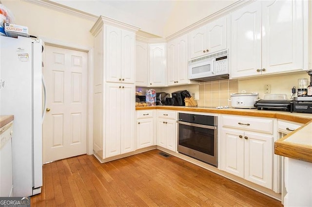 kitchen featuring light wood-style flooring, tasteful backsplash, white cabinetry, white appliances, and light countertops