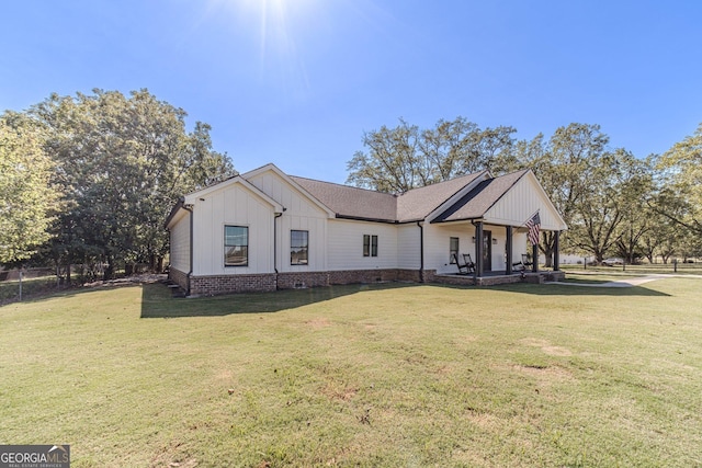 modern farmhouse with a front yard, fence, and board and batten siding