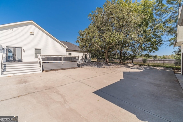 view of patio featuring a wooden deck and fence