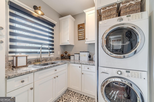 laundry area with light tile patterned floors, cabinet space, stacked washer and clothes dryer, and a sink