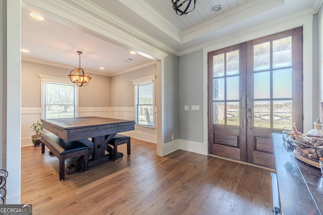 entrance foyer with plenty of natural light, french doors, an inviting chandelier, and wood finished floors