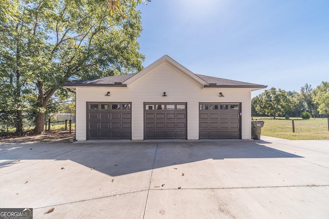 garage with driveway and fence