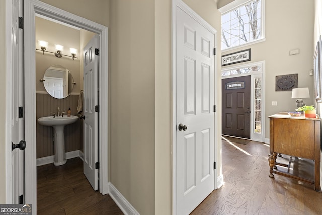 entryway with baseboards and dark wood-style flooring