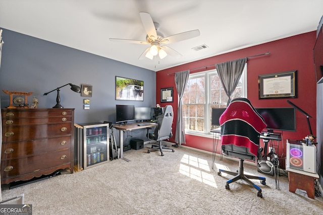 carpeted office featuring visible vents and ceiling fan