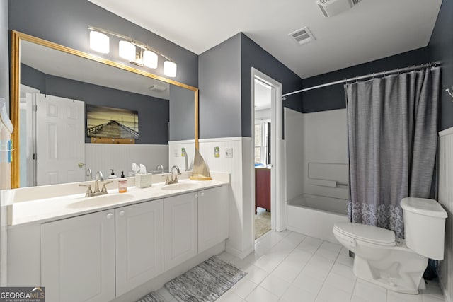 full bath featuring a wainscoted wall, toilet, visible vents, and a sink