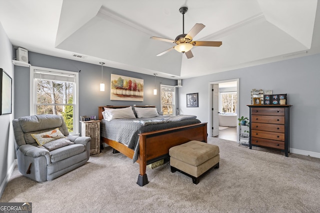 carpeted bedroom with a tray ceiling, baseboards, visible vents, and a ceiling fan