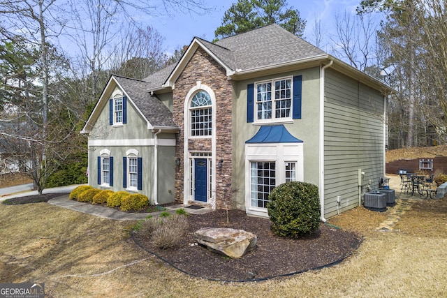 view of front of house featuring stone siding, roof with shingles, and stucco siding