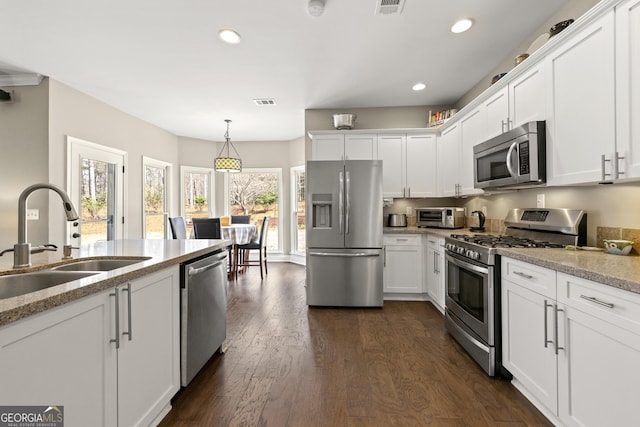 kitchen featuring a sink, dark wood finished floors, white cabinetry, recessed lighting, and stainless steel appliances