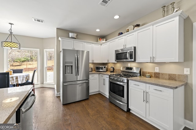 kitchen with dark wood finished floors, visible vents, white cabinets, and appliances with stainless steel finishes