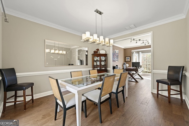 dining room featuring visible vents, an inviting chandelier, wood finished floors, and ornamental molding