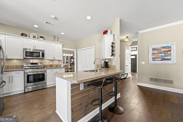 kitchen with a sink, a peninsula, visible vents, and stainless steel appliances