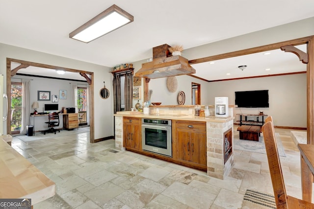 kitchen featuring stone tile flooring, open floor plan, recessed lighting, stainless steel oven, and baseboards