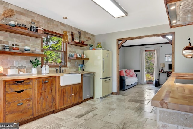 kitchen featuring open shelves, a sink, backsplash, stone tile flooring, and dishwasher