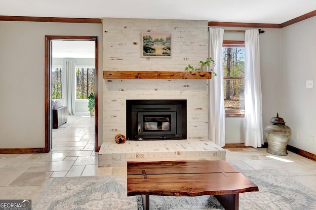 living room with crown molding, stone tile floors, a fireplace, and baseboards