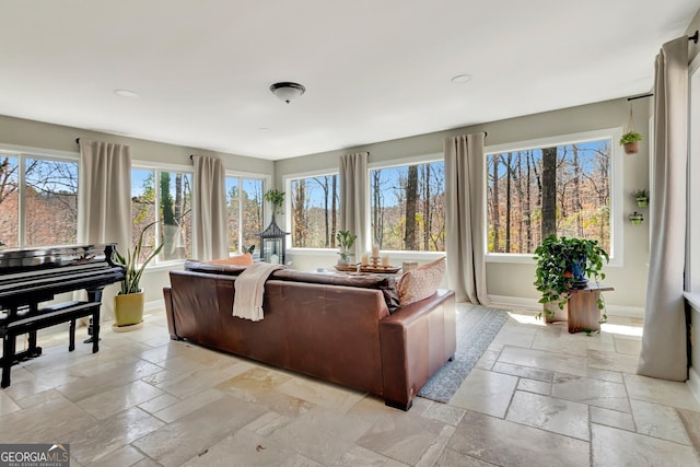 living room featuring stone tile floors and baseboards