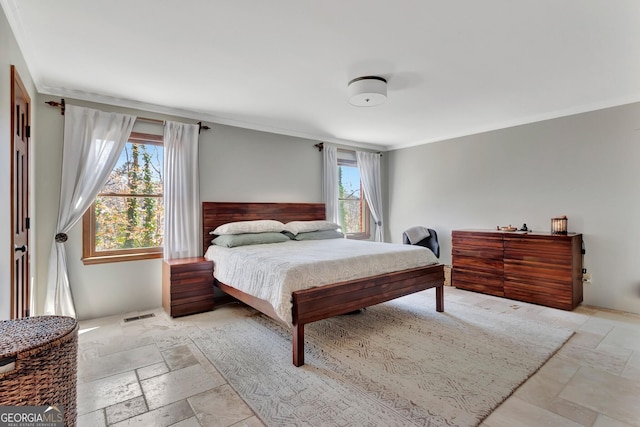 bedroom featuring stone tile floors, visible vents, and crown molding