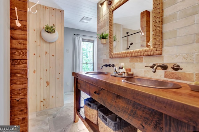 bathroom with decorative backsplash, double vanity, a shower, and a sink