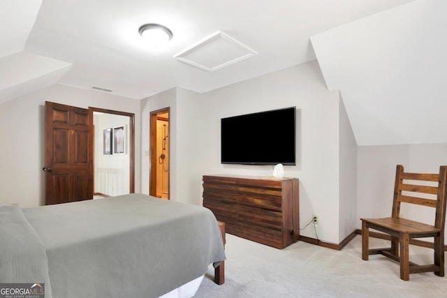 bedroom with visible vents, light carpet, attic access, and vaulted ceiling