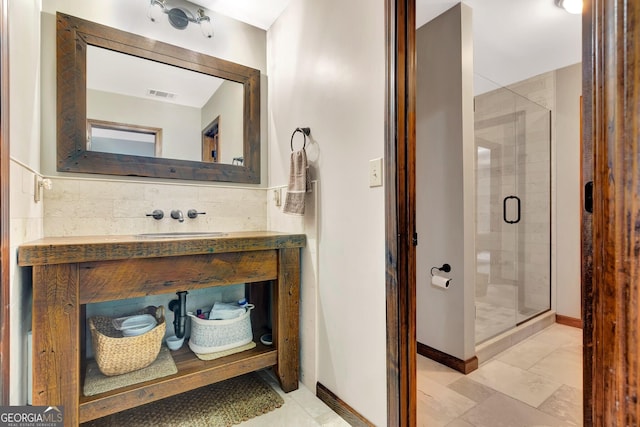 bathroom with vanity, a shower stall, baseboards, and visible vents