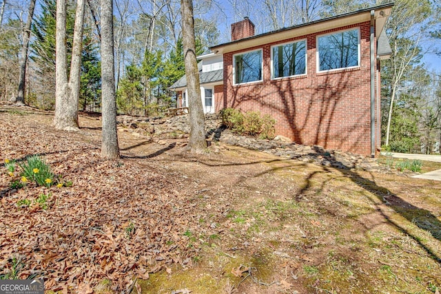 view of home's exterior featuring brick siding and a chimney