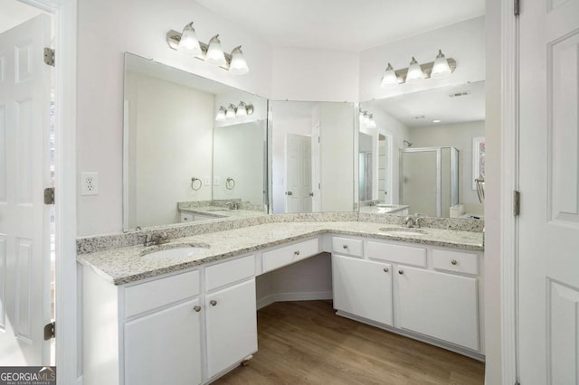 10950 Glenhurst Pass, Duluth, GA 30097 - full bathroom featuring a stall shower, wood finished floors, and double vanity