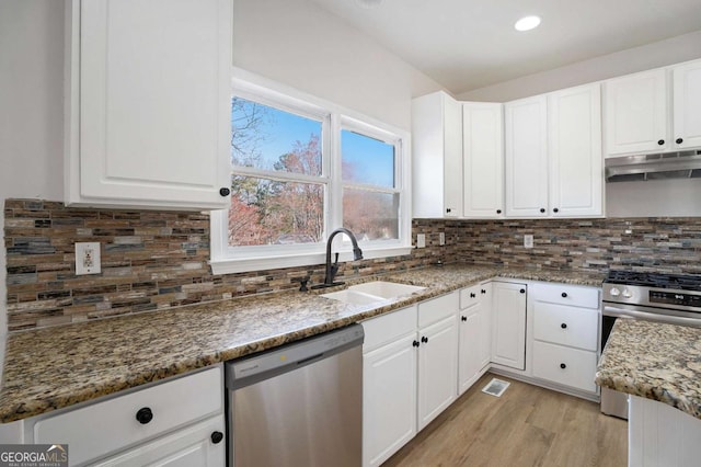 10950 Glenhurst Pass, Duluth, GA 30097 - kitchen with under cabinet range hood, appliances with stainless steel finishes, a sink, backsplash, and white cabinetry