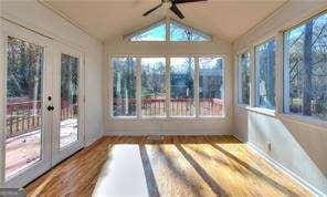 unfurnished sunroom featuring lofted ceiling and a ceiling fan