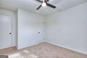 empty room with a ceiling fan and baseboards