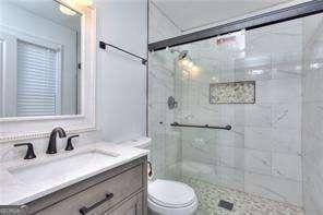 bathroom with vanity, a shower stall, and toilet