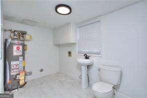 bathroom featuring gas water heater and toilet