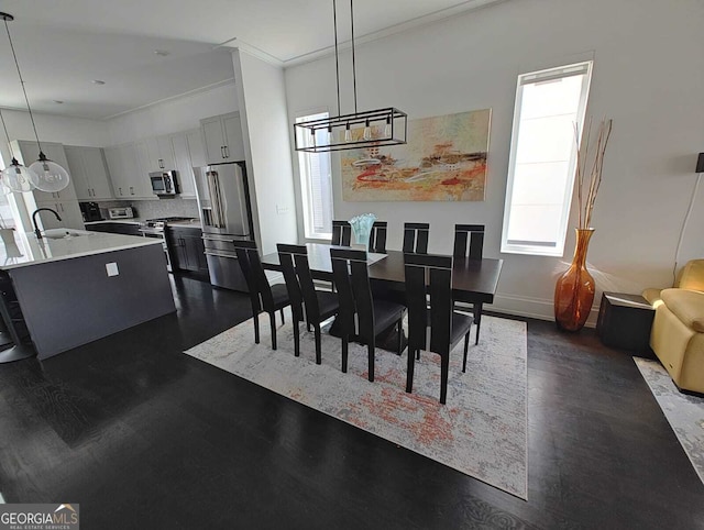 dining room featuring a notable chandelier, baseboards, and ornamental molding