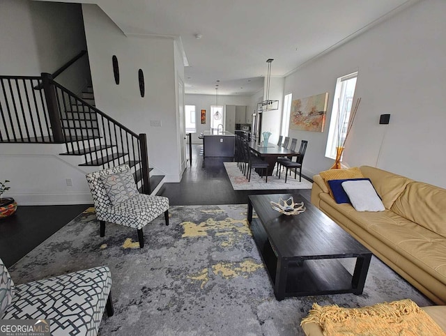 living room featuring stairs, wood finished floors, and baseboards