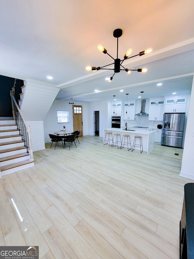 dining space featuring a chandelier, stairs, and light wood finished floors