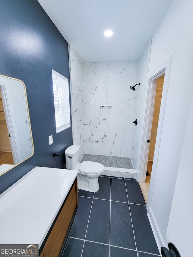 bathroom featuring tile patterned floors, a stall shower, toilet, and vanity