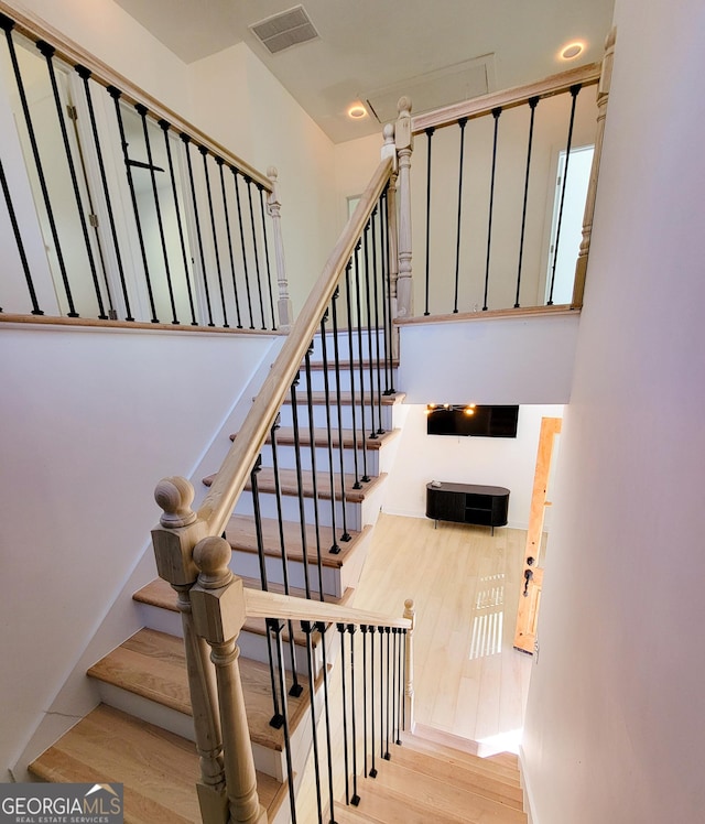 staircase with wood finished floors and visible vents